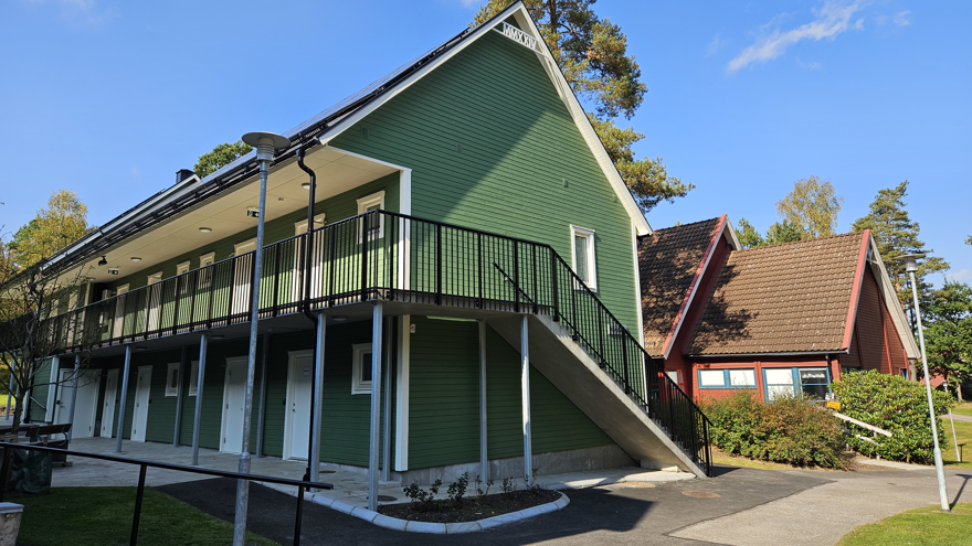 Svenljungas internat med en grön tvåvåningsbyggnad i förgrunden och en röd byggnad bakom