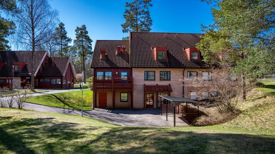 Skolans internatboende med omgivande miljö mot blå himmel