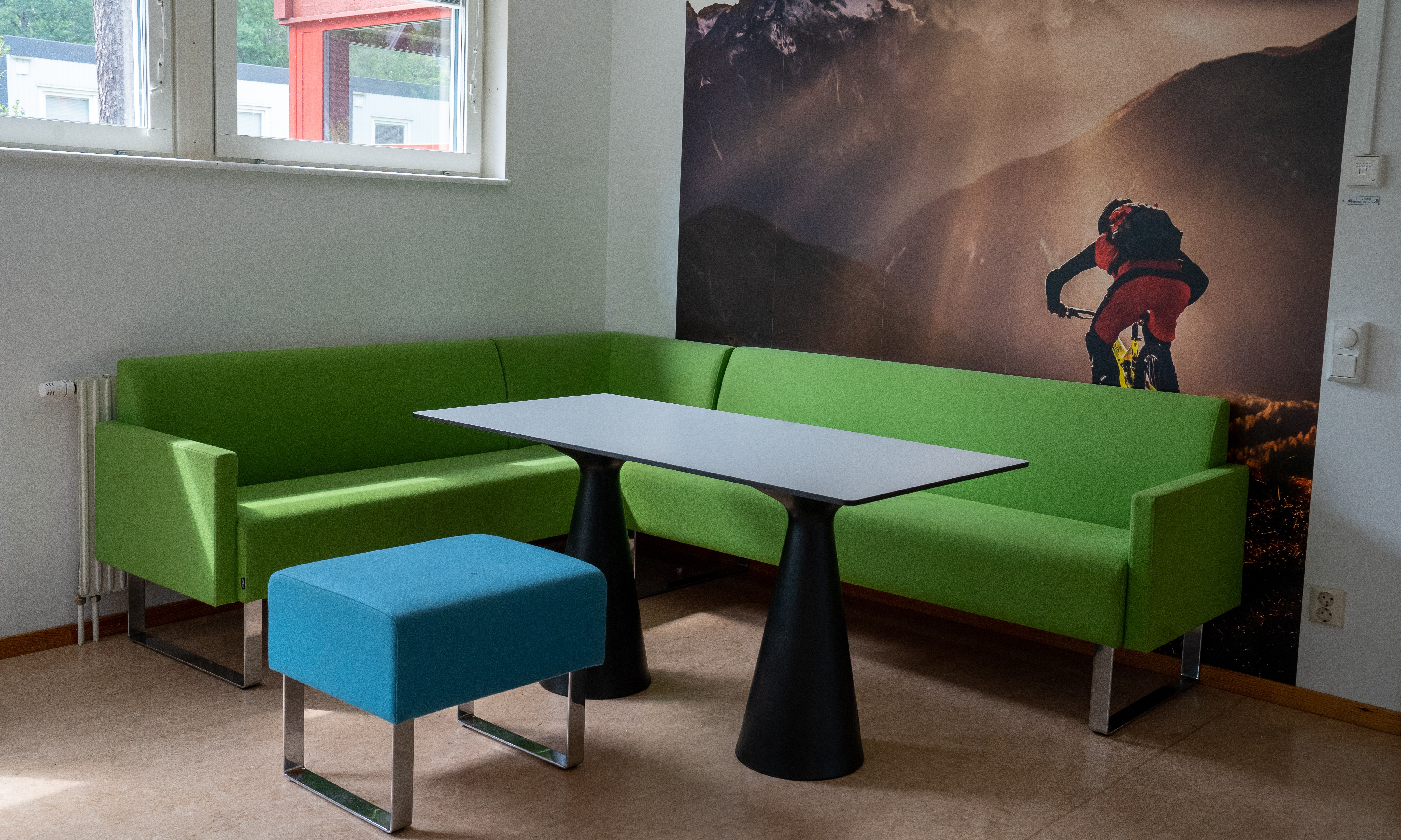 Soffa och pall runt ett bord med stor mountainbike-tavla i bakgrunden