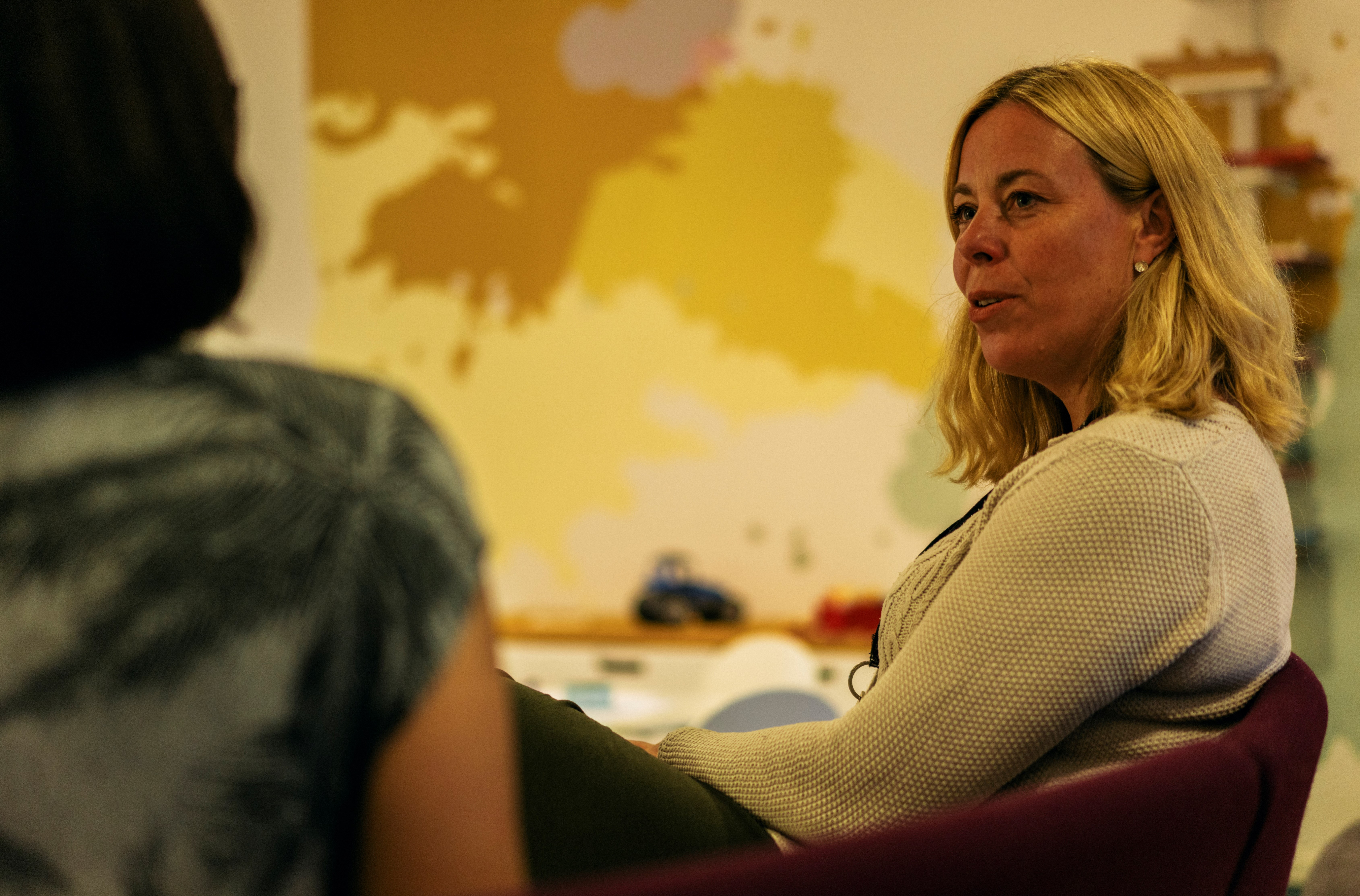 Två personer sitter och samtalar i en soffa.