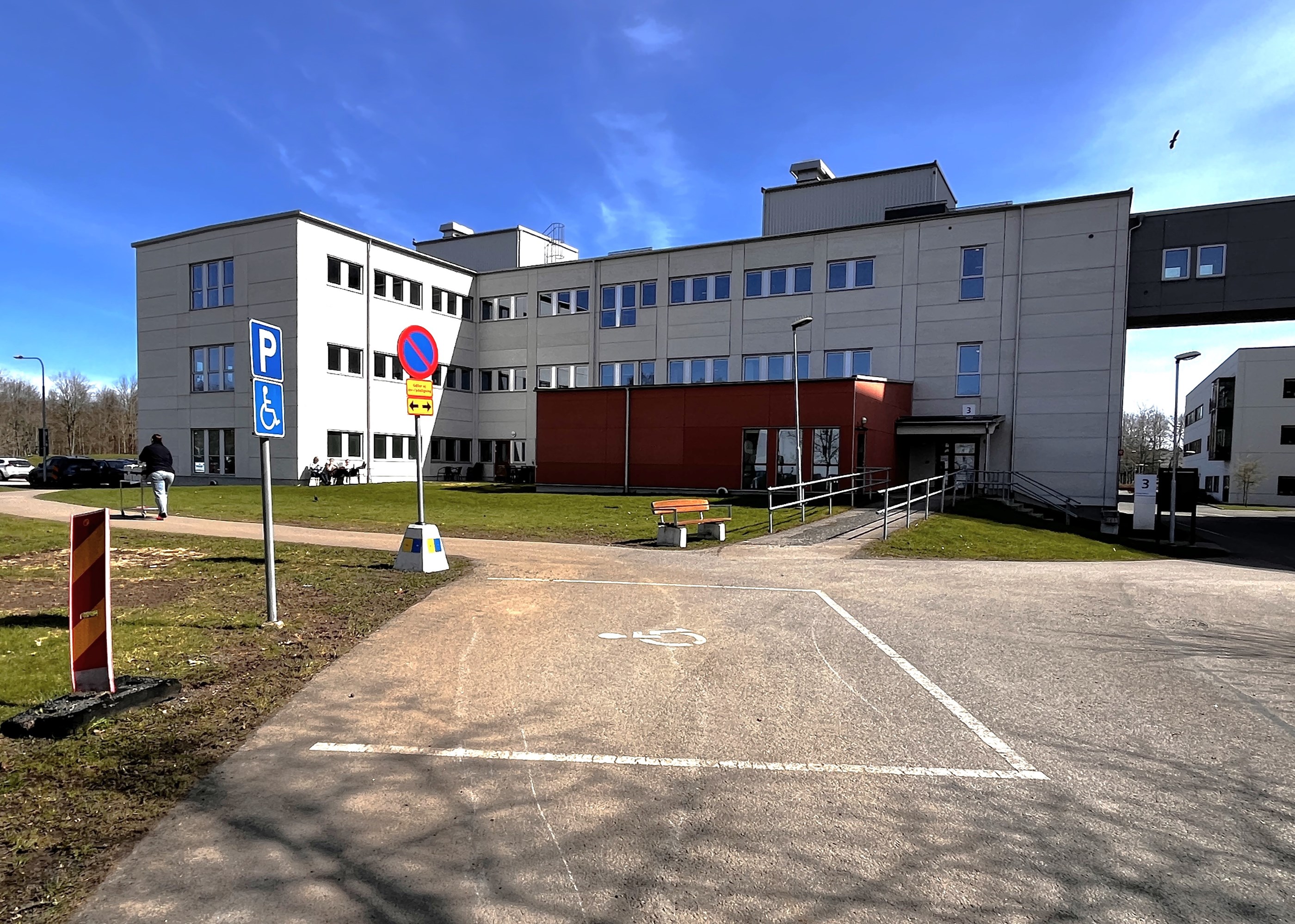 Vitt hus med orangebrun utbyggnad vid entrén.