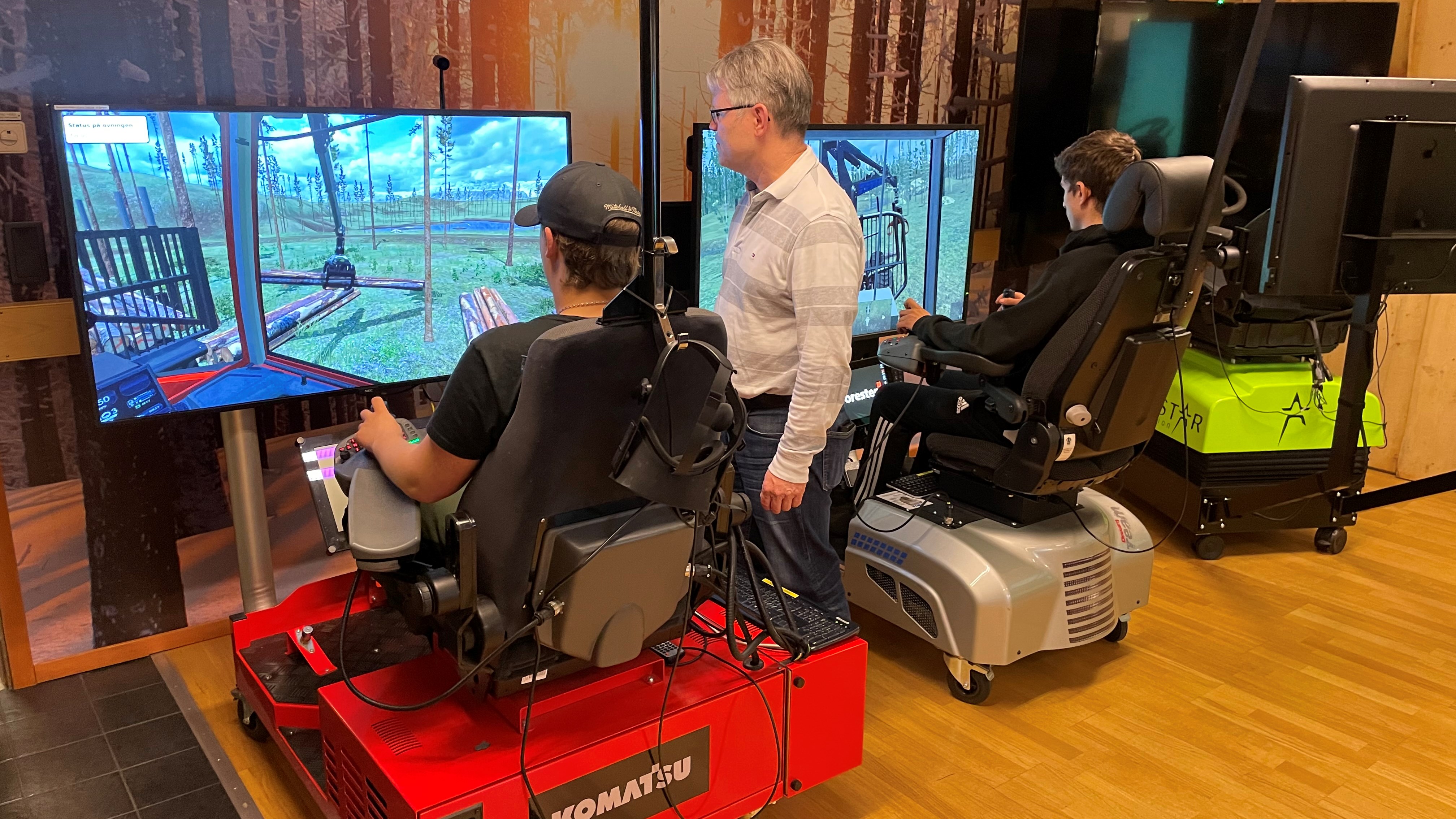 Elever sitter i simulatorer och kör skogsmaskin