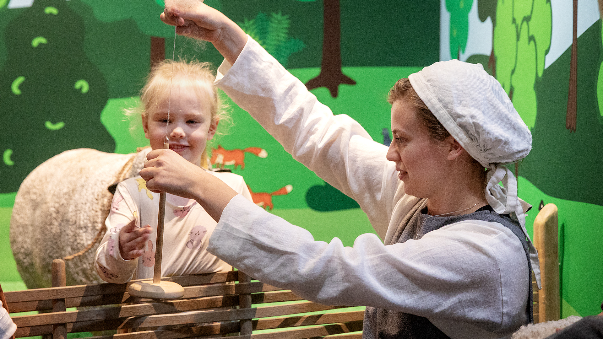 Kvinna och barn i lekmiljö i utställningen