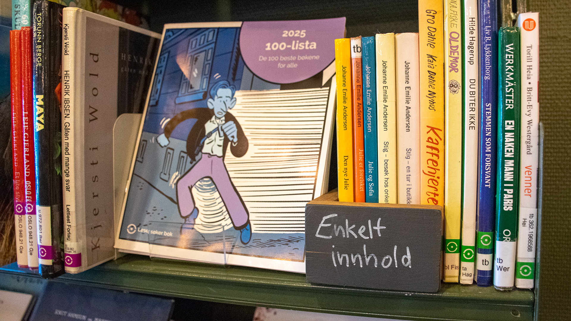 En närbild på en hylla i en bokhylla. En skylt på hyllan har texten "Enkelt innhold". 