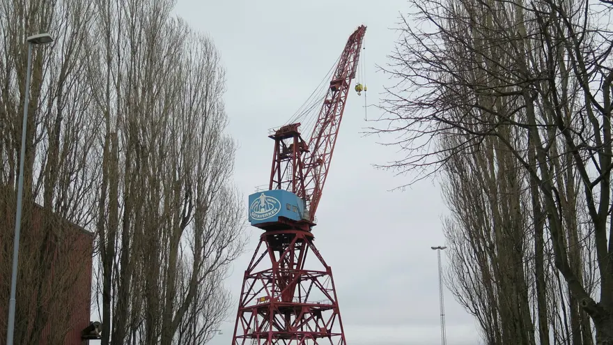 Kran 43 snett bakifrån sett från vägkanten med träd i förgrunden